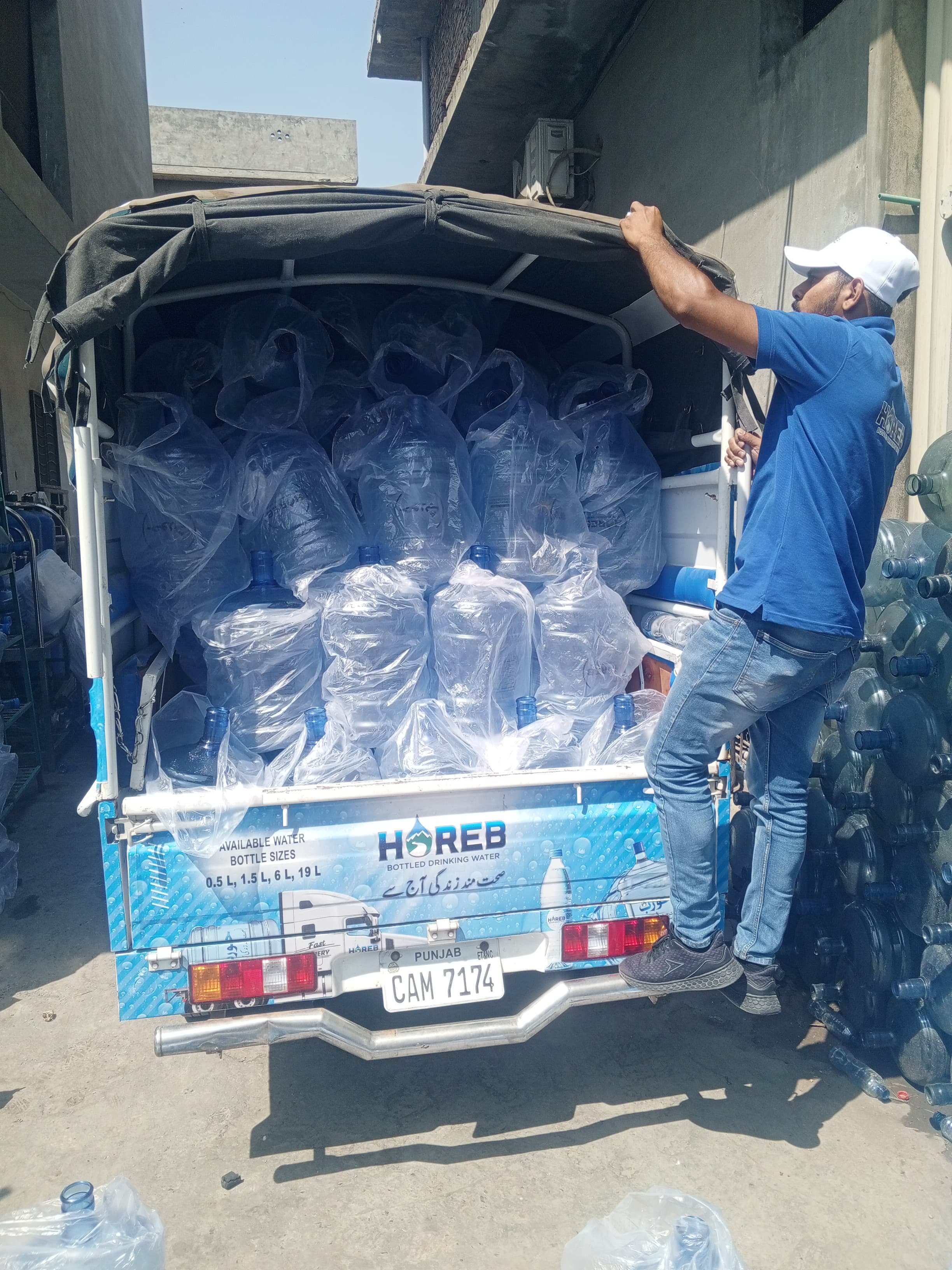 A Horeb water delivery vehicle being loaded with sealed 19-litre bottles